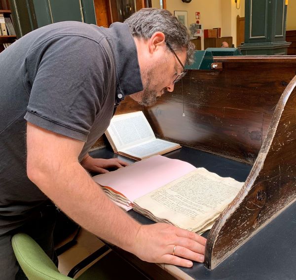 David Govantes Edwards inspects a 14th century manuscript for information on Spanish glass production